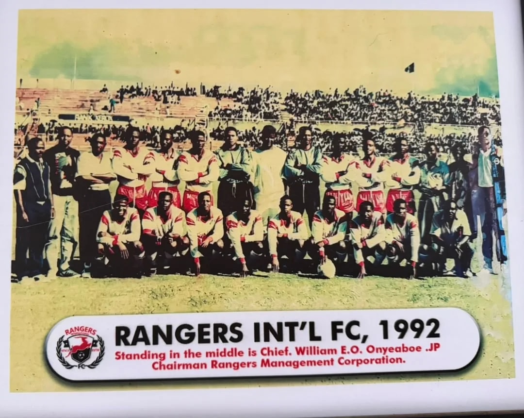 The 1992 Rangers squad and officials lined up on the pitch before a full stadium.
